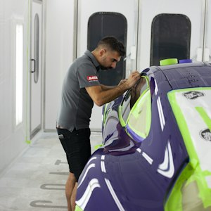 Technician in protective gear preparing a car